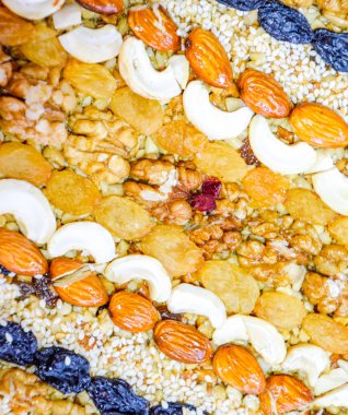 Kozinaki deli ve tohum ile kaplı. Badem, kaju fıstığı ve kuru üzüm.