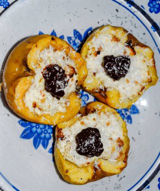 Elma süzme peynir ile pişmiş ve çikolata ve hindistan cevizi cips ile dekore.