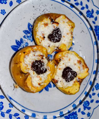 Elma süzme peynir ile pişmiş ve çikolata ve hindistan cevizi cips ile dekore.