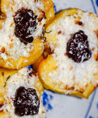 Elma süzme peynir ile pişmiş ve çikolata ve hindistan cevizi cips ile dekore.