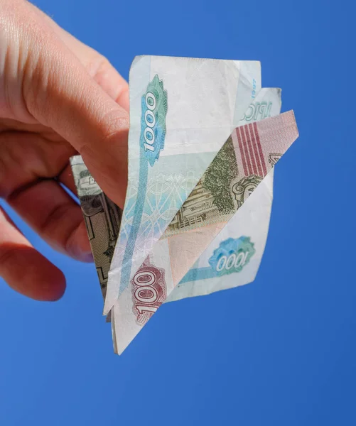 Деноминации русских денег, сложенных в самолете против голубого неба в руке — стоковое фото