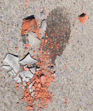 Asfalt üzerinde kırık tuğla ve kayrak parçaları