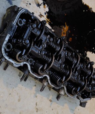Silindir bloğunun başı. Silindir bloğunun başı tamir için motordan çıkarıldı. Motor yağının parçaları. Araç motoru tamiri serviste.