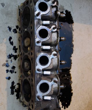 Silindir bloğunun başı. Silindir bloğunun başı tamir için motordan çıkarıldı. Motor yağının parçaları. Araç motoru tamiri serviste.