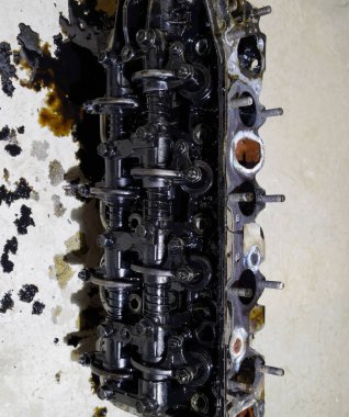 Silindir bloğunun başı. Silindir bloğunun başı tamir için motordan çıkarıldı. Motor yağının parçaları. Araç motoru tamiri serviste.