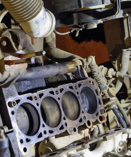 The cylinder block of the four-cylinder engine. Disassembled motor vehicle for repair. Parts in engine oil. Car engine repair in the service — Stock Photo, Image