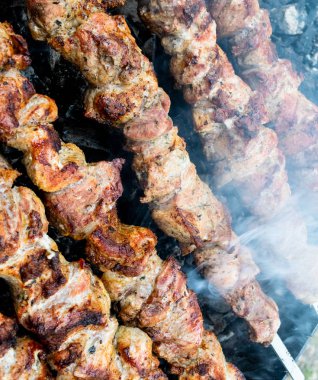 Bir brazier üzerinde bir şiş üzerinde domuz kızartma. Eti kömürlerin üzerine çevirmek. Iştah açıcı şiş kebap.