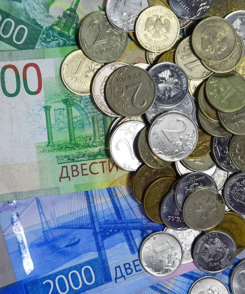 Billets et pièces russes. Une poignée de pièces sur les nouveaux billets russes en coupures de 2000 et 200 roubles . — Photo