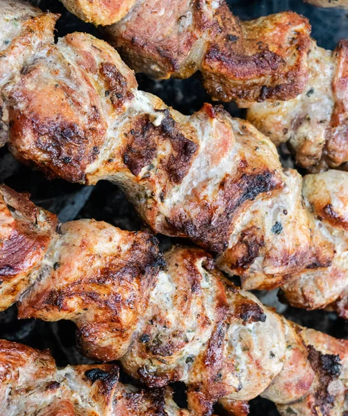 Faire frire du porc sur une brochette au-dessus d'un brasero. Retourner la viande sur les charbons. Chiche kebab appétissant . — Photo