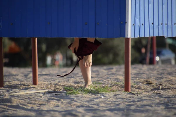 Гардеробная на пляже, ноги девушки видны из раздевалки — стоковое фото