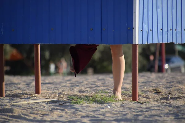 Гардеробная на пляже, ноги девушки видны из раздевалки — стоковое фото