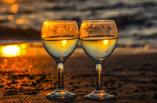 Copo de champanhe na praia ao pôr-do-sol fundo . — Fotografia de Stock