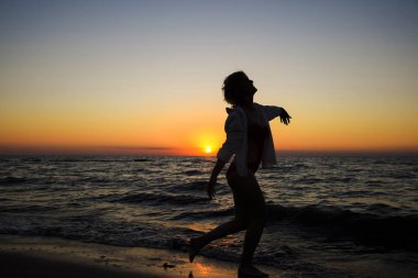 şampanya bir bardak ile kız deniz kıyısında dans ediyor.
