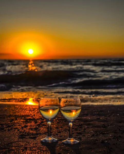 Copo de champanhe na praia ao pôr-do-sol fundo . — Fotografia de Stock