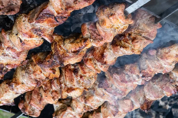 Faire frire du porc sur une brochette au-dessus d'un brasero. Retourner la viande sur les charbons. Chiche kebab appétissant . — Photo