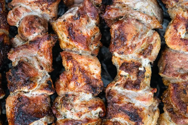 Frituur varkensvlees op een spies boven een Vuurkorf. Het draaien van vlees over kolen. Smakelijke Shish Kebab. — Stockfoto