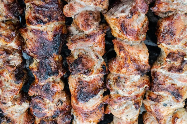 Faire frire du porc sur une brochette au-dessus d'un brasero. Retourner la viande sur les charbons. Chiche kebab appétissant . — Photo