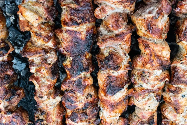 Faire frire du porc sur une brochette au-dessus d'un brasero. Retourner la viande sur les charbons. Chiche kebab appétissant . — Photo