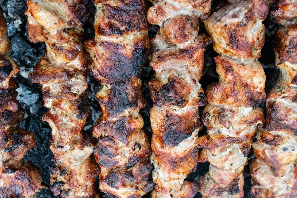 Bir brazier üzerinde bir şiş üzerinde domuz kızartma. Eti kömürlerin üzerine çevirmek. Iştah açıcı şiş kebap.