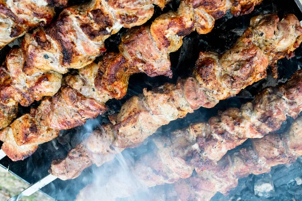 Faire frire du porc sur une brochette au-dessus d'un brasero. Retourner la viande sur les charbons. Chiche kebab appétissant . — Photo