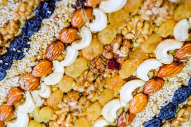 Kozinaki deli ve tohum ile kaplı. Badem, kaju fıstığı ve kuru üzüm.