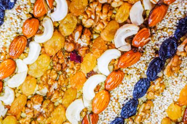 Kozinaki deli ve tohum ile kaplı. Badem, kaju fıstığı ve kuru üzüm.