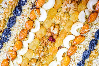 Kozinaki deli ve tohum ile kaplı. Badem, kaju fıstığı ve kuru üzüm.