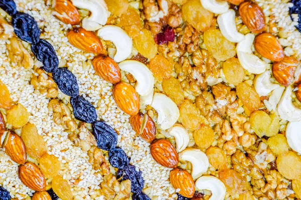 Kozinaki deli ve tohum ile kaplı. Badem, kaju fıstığı ve kuru üzüm.