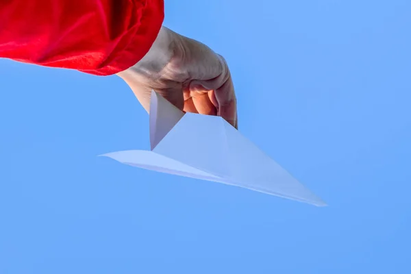 White paper airplane in hand against the sky. A symbol of freedom on the Internet — Stock Photo, Image