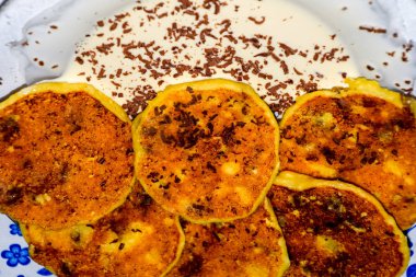 Tabakta ekşi krema ve çikolata parçacıkları ile Cheesecakes.