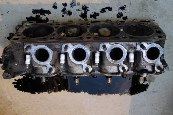 Silindir bloğunun başı. Silindir bloğunun başı tamir için motordan çıkarıldı. Motor yağının parçaları. Araç motoru tamiri serviste.