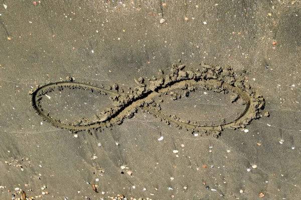 Знак бесконечности на море. Береговой песок на пляже. Символ бесконечности — стоковое фото