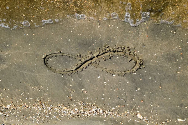 A jel a végtelenség a tengerparton. Tengerparti homok a tengerparton. A végtelenség szimbóluma — Stock Fotó