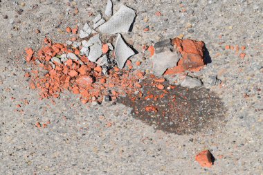 Asfalt üzerinde kırık tuğla ve kayrak parçaları