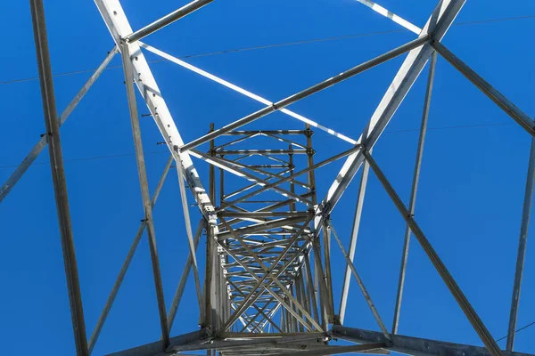 Unterstützt Hochspannungsleitungen gegen den blauen Himmel. Blick von unten nach oben — Stockfoto