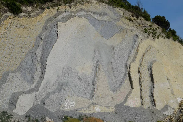 Inclinação da montanha com camadas de rochas sedimentares. Rochas sedimentares localizadas verticalmente na encosta em colapso . — Fotografia de Stock