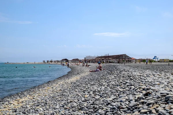 Beach canopies for protection from the sun on the seashore. Pebble beach Aleksino in Novorossiysk. — Stock Photo, Image