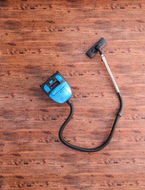 Odada yerde elektrik süpürgesi var.