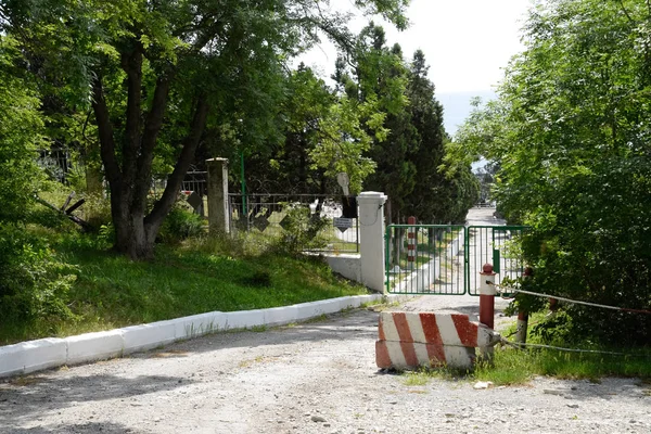 gate of the summer house of a corrupt official on the seashore. The thug general built his country house and put up a fence.