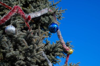 Süslemeleri yılbaşı ağacı. Tinsel ve oyuncaklar, topları ve diğer süslemeleri Noel Noel ayakta açık havada ağaç.
