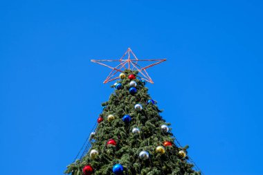 Süslemeleri yılbaşı ağacı. Tinsel ve oyuncaklar, topları ve diğer süslemeleri Noel Noel ayakta açık havada ağaç.