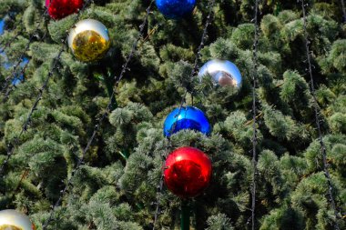 Süslemeleri yılbaşı ağacı. Tinsel ve oyuncaklar, topları ve diğer süslemeleri Noel Noel ayakta açık havada ağaç.