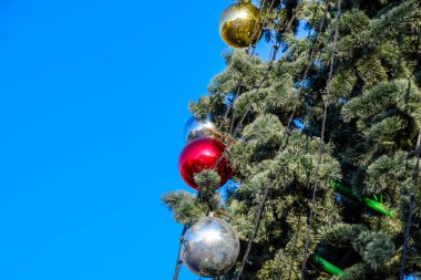 Süslemeleri yılbaşı ağacı. Tinsel ve oyuncaklar, topları ve diğer süslemeleri Noel Noel ayakta açık havada ağaç.