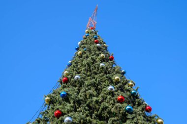 Süslemeleri yılbaşı ağacı. Tinsel ve oyuncaklar, topları ve diğer süslemeleri Noel Noel ayakta açık havada ağaç.
