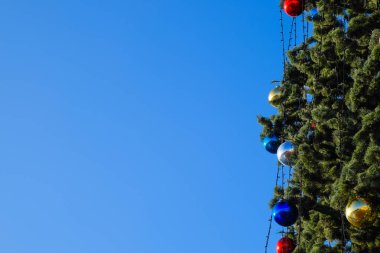Süslemeleri yılbaşı ağacı. Tinsel ve oyuncaklar, topları ve diğer süslemeleri Noel Noel ayakta açık havada ağaç.