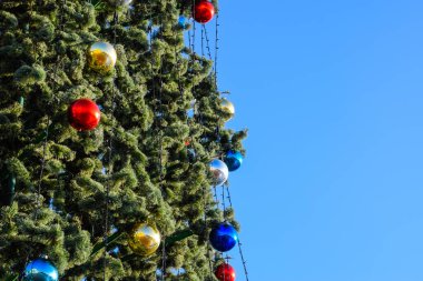 Süslemeleri yılbaşı ağacı. Tinsel ve oyuncaklar, topları ve diğer süslemeleri Noel Noel ayakta açık havada ağaç.