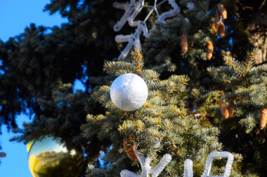 Süslemeleri yılbaşı ağacı. Tinsel ve oyuncaklar, topları ve diğer süslemeleri Noel Noel ayakta açık havada ağaç.