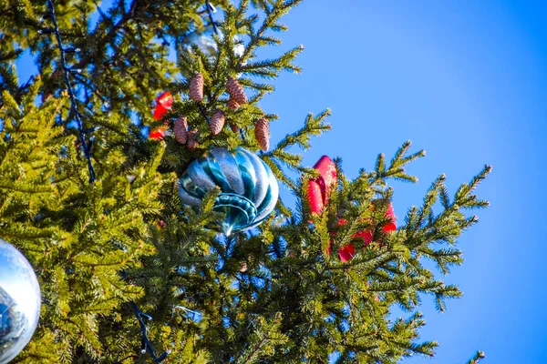 Dekorationen Neujahrsbaum. Lametta und Spielzeug, Kugeln und andere Dekorationen am Weihnachtsbaum im Freien. — Stockfoto