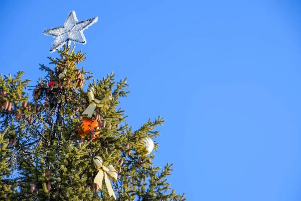 Dekorationen Neujahrsbaum. Lametta und Spielzeug, Kugeln und andere Dekorationen am Weihnachtsbaum im Freien. — Stockfoto