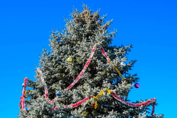 Decoraciones árbol de Año Nuevo. Hojalata y juguetes, bolas y otras decoraciones en el árbol de Navidad de pie al aire libre . — Foto de Stock